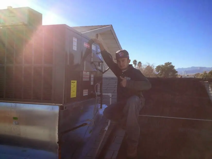 HVAC technician performing Heat Pump Repair on a rooftop unit in Westwood